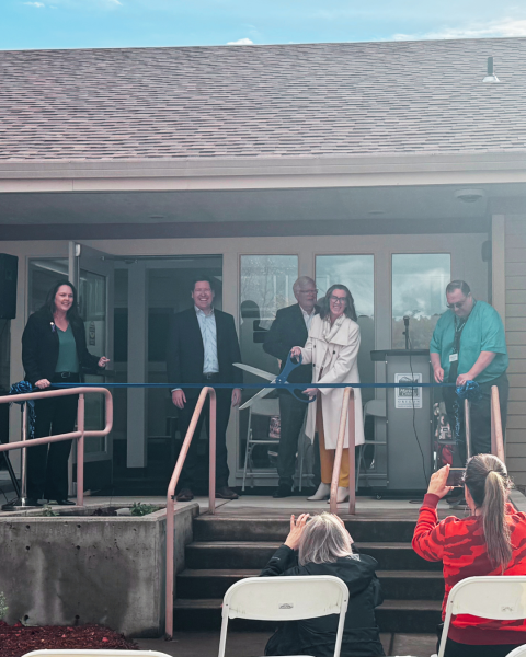 a group of people cutting a ribbon